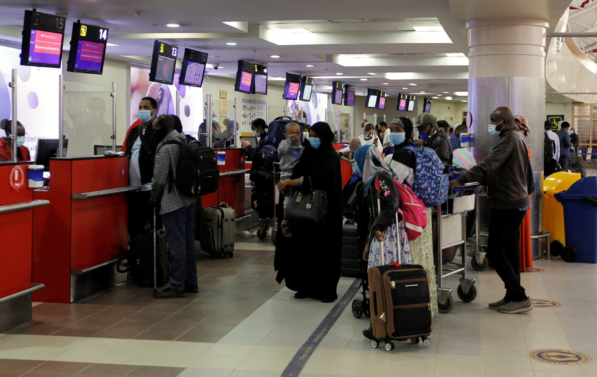 Inside a long-distance bus during COVID-19 curfew, dim lights, masked passengers, quiet uncertainty